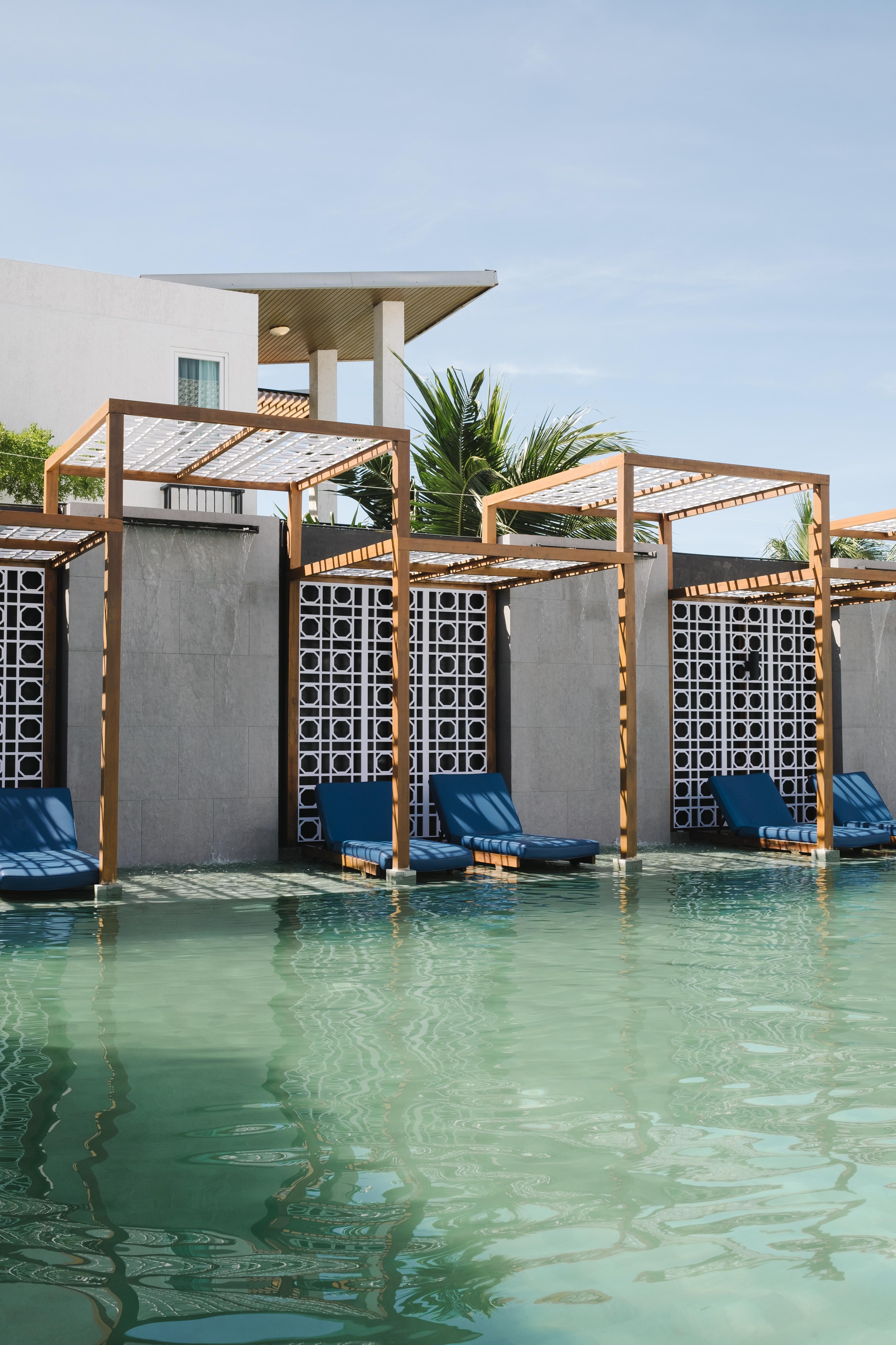 Relaxing view of a beach from a hotel balcony with chairs.